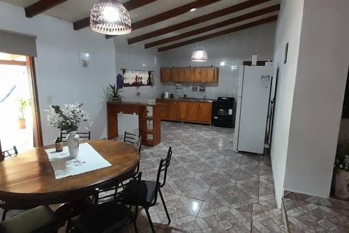a kitchen and dining room with a table and a refrigerator at Karina House in Jardín América