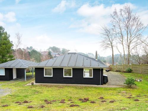 a black house with a black roof at 6 person holiday home in Knebel in Knebel