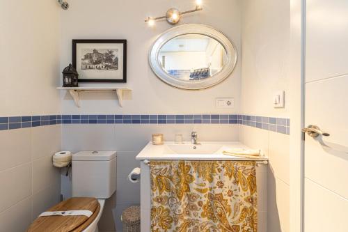 a bathroom with a sink and a toilet and a mirror at Entre Bodegas Jerez in Jerez de la Frontera