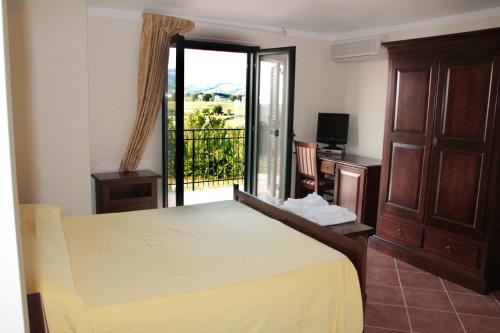 a bedroom with a large bed and a balcony at San Nicola Il Sole in Albanella
