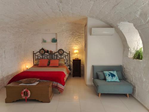 a bedroom with a bed and a couch and a chair at B&B La Torretta in Bitritto