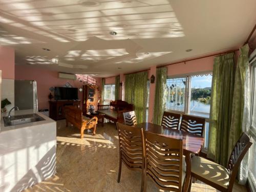 a living room with a table and chairs and a kitchen at Cozy Home With Lake View at Kathu PHUKET 3 BR in Ban Huai Luk (1)