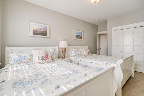 a white bedroom with two beds in it at The Driftwood in Depoe Bay