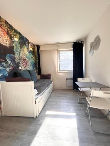 une petite pièce avec un lit et une table dans l'établissement Lovely, à Bordeaux