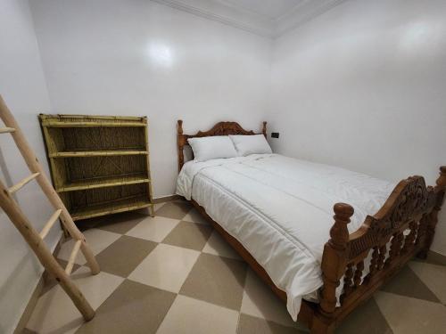 a bedroom with a wooden bed with a tiled floor at Green Surf House in Agadir