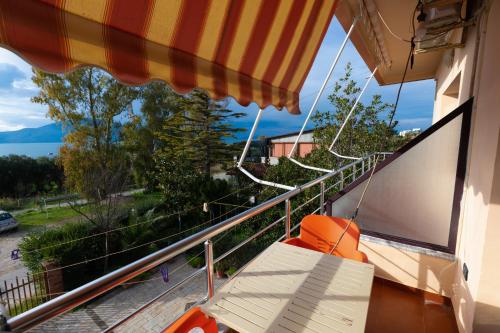 a balcony with a chair and an umbrella at Sulo Villa in Vlorë