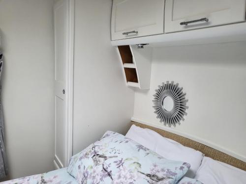 a small bedroom with a bed and a mirror at Glamping with Llamas in Wisbech