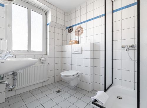 a white bathroom with a toilet and a sink at Hotel am Ludwigsplatz in Gießen