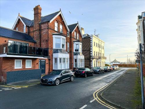 a row of cars parked on the side of a street at Brooklands Filey Seaside Retreat Flat 6 in Filey