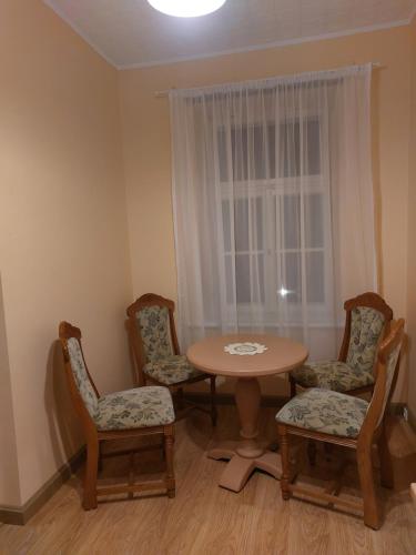 une chambre avec une table, des chaises et une fenêtre dans l'établissement Pils ielas apartamenti, à Kandava