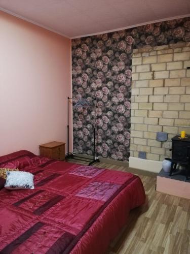 a bedroom with a red bed and a brick wall at Pils ielas apartamenti in Kandava