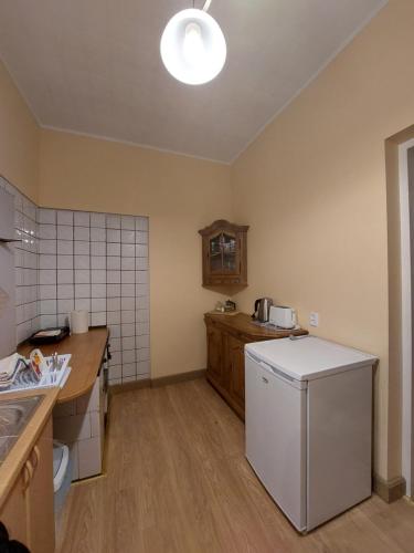 a kitchen with a white refrigerator in a room at Pils ielas apartamenti in Kandava