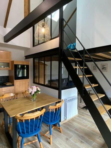une salle à manger avec une table en bois et des chaises bleues dans l'établissement Maisonnette,100m mer, proche St Malo/Cancale, WIFI, à Saint-Benoît-des-Ondes