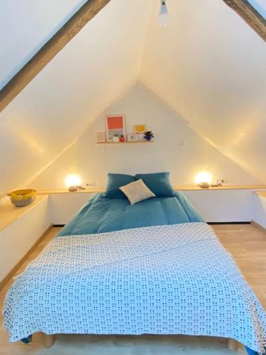 - une chambre mansardée avec un lit bleu dans l'établissement Maisonnette,100m mer, proche St Malo/Cancale, WIFI, à Saint-Benoît-des-Ondes