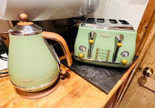 a green toaster sitting on a counter next to a blender at Cosy Cottage in Central Reading Free Parking & Fast Wifi in Reading