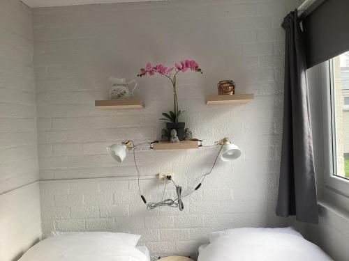 a bedroom with two lights on the wall and flowers at Casa della nonna bungalow 2 in Simpelveld