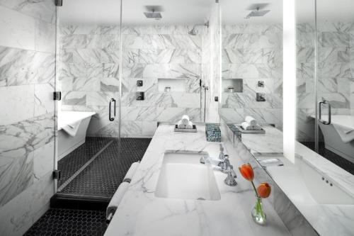 a white bathroom with two sinks and a shower at The St. Anthony, a Luxury Collection Hotel, San Antonio in San Antonio
