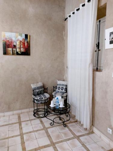 a room with two chairs and a table and a curtain at Riad Ain Khadra in Taroudant
