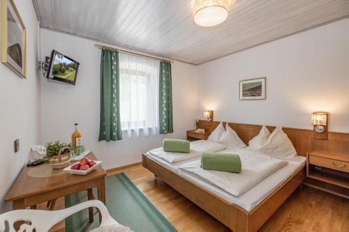 a bedroom with a bed and a desk and a table at Gasthof-Pension Sandwirt in Grades