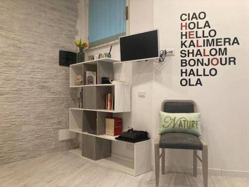a room with a chair and a book shelf at CASA TUA in Ivrea