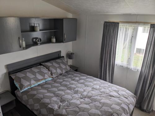 um quarto com uma cama e uma janela em Static Caravan on Lady's Mile Holiday Park em Dawlish