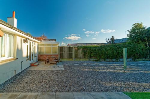 a backyard with a bench and a house at Modern, but cosy Bungalow in Queensbury