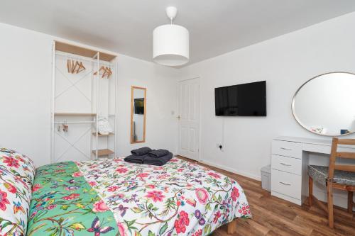 a bedroom with a bed and a desk and a mirror at Home Sweet Bungalow in Queensbury