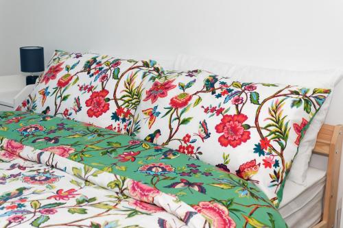 a white couch with floral pillows on it at Home Sweet Bungalow in Queensbury