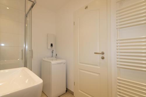 a bathroom with a toilet and a sink and a shower at Ferienwohnung Strandrose in Hörnum
