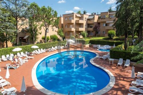einen Pool mit Liegestühlen und ein Resort in der Unterkunft Vita Loca Apartments in Peschiera del Garda