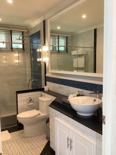 a bathroom with a sink and a toilet and a mirror at Seapine Beach Golf and Resort Hua Hin in Hua Hin