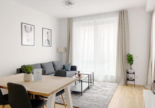 uma sala de estar com um sofá e uma mesa em Moderne Apartments im Herzen der Stadt I private Tiefgarage mit Ladesäulen I home2share em Ibbenbüren