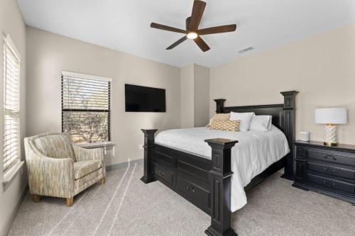 a bedroom with a bed with a ceiling fan and a chair at Peaceful Hill Country Oasis in Kyle