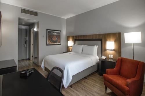 a hotel room with a bed and a chair at Marriott São Paulo Airport Hotel in Guarulhos