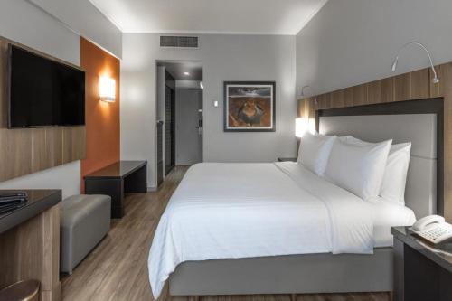 a hotel room with a bed and a television at Marriott São Paulo Airport Hotel in Guarulhos