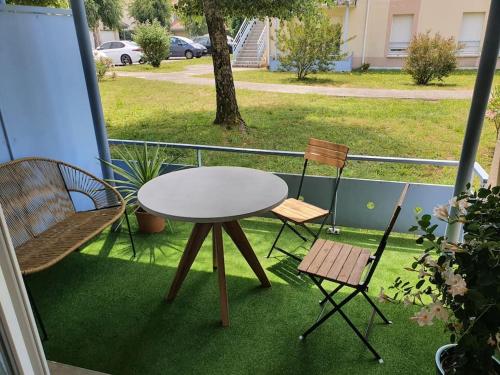 uma mesa e duas cadeiras numa varanda em Mignon appartement en résidence avec piscine em Biscarrosse
