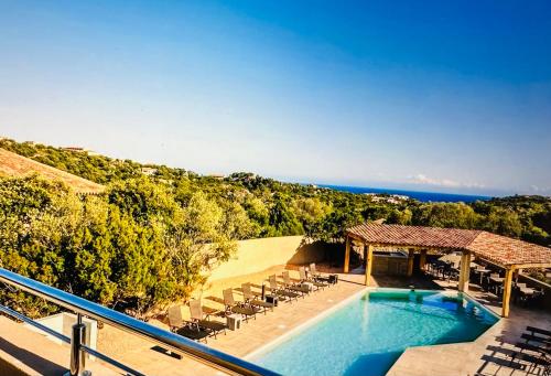- une vue sur la piscine avec des chaises et l'océan dans l'établissement Residence Casa Di Paoli, à Porto-Vecchio