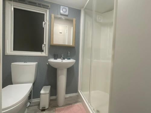 uma casa de banho com um WC, um lavatório e um chuveiro em ISMA em Knaresborough