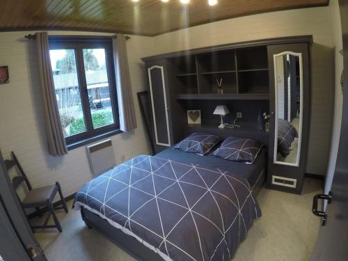 杜柏的住宿－Chalet Balthazar，卧室设有一张蓝色大床和一扇窗户。
