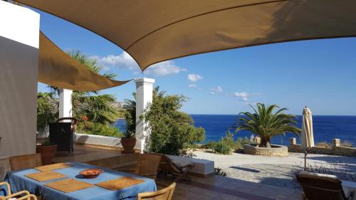 a patio with a table and a view of the ocean at Tranquil Villa with Sea view in Ammopi Karpathos in Amoopi