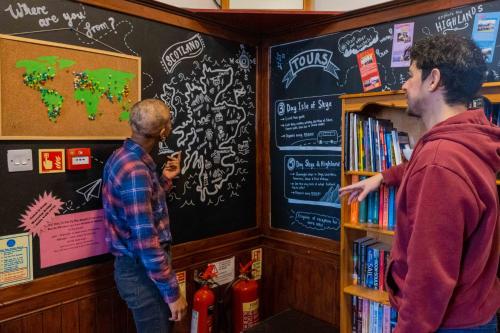 two men standing in front of a book shelf in a library at Royal Mile Backpackers in Edinburgh