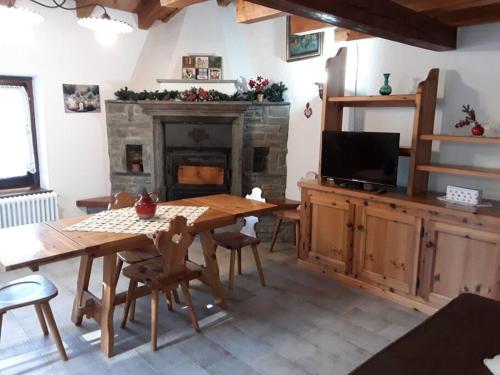 ein Wohnzimmer mit einem Tisch und einem Kamin in der Unterkunft Tana della volpe 1 in Gressan