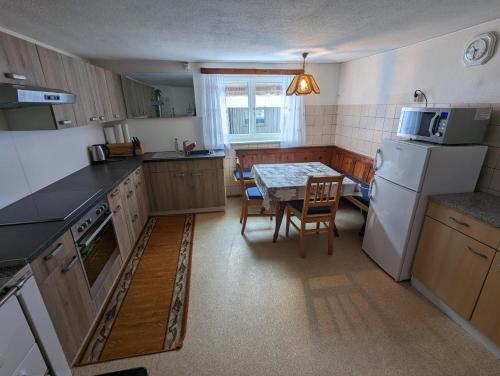 a kitchen with a table and a white refrigerator at Ferienhaus Fatlar in Kappl