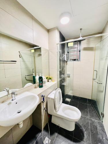 a bathroom with a sink and a toilet and a mirror at AJ Suites @ Loft Imago KK in Kota Kinabalu