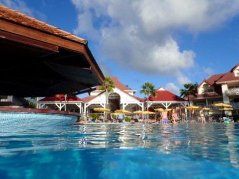 a swimming pool with water fountain in front of a resort at Pierre & Vacances Antigua 03 in Sainte-Luce