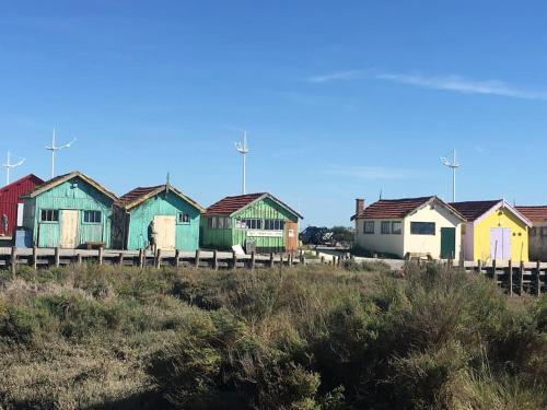 una fila de casas coloridas en una playa en Appartement cosy à Boyardville en Boyardville