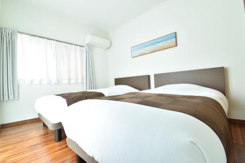 a bedroom with two beds and a window at YADO Kukkal- Vacation STAY 48433v in Amami