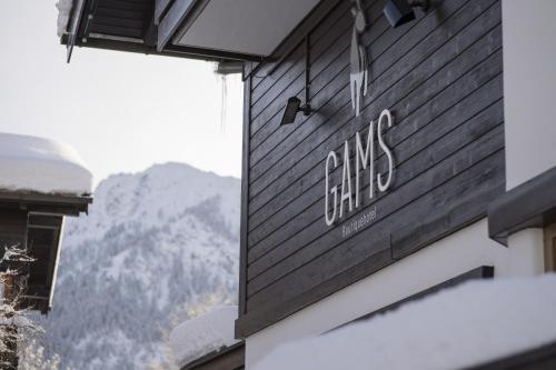 a sign on the side of a building with mountains in the background at Boutique Hotel Gams in Oberstdorf