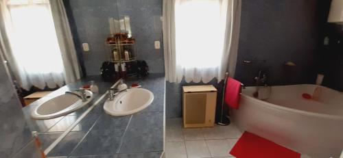 a bathroom with two sinks and a bath tub at Nyaralóház HANGA in Fonyód