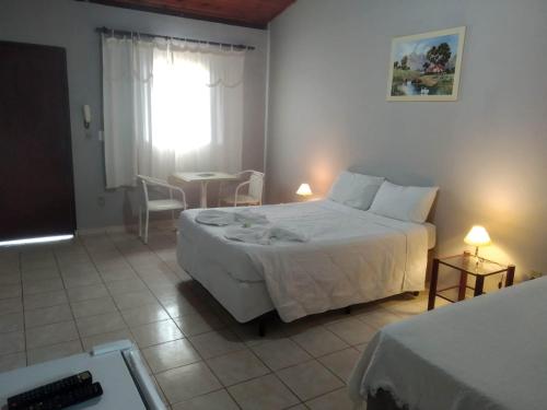 ein Schlafzimmer mit einem großen weißen Bett und einem Fenster in der Unterkunft Pousada Luz da Lua in Socorro